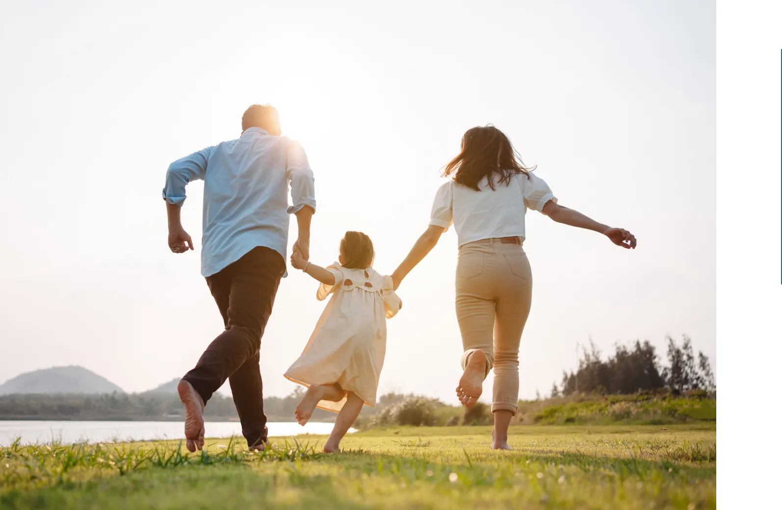 Family runs barefoot in sunset.